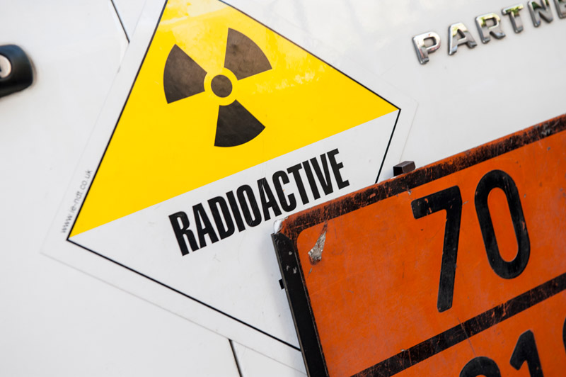 Plaque de couleur orange et trisecteur sur véhicule indiquant le transport d'une source radioactive