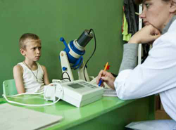 Un garçon passe un examen médical pour rechercher des arythmies cardiaques soupçonnées d'être engendrées par les radiations à faible dose.©Noak/Le bar Floréal/IRSN 