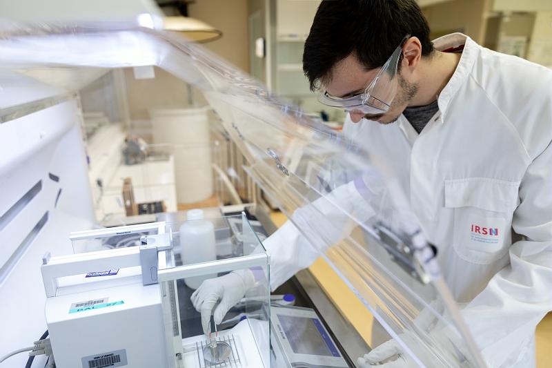 lab LEI- zone de préparation liquide du laboratoire, Nathan Liebgott technicien contrôle quotidiennement les balances de précision du poste de pesée - © Médiathèque IRSN
